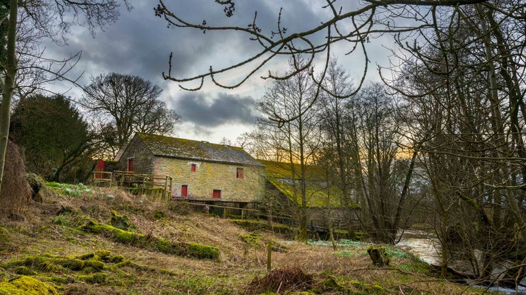 The Mill at Acorn Bank, Cumbria with a cloudy February sky